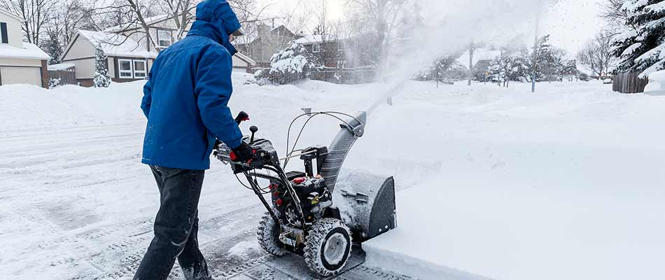 A snow removal worker using a snow blower in Sartell, MN.